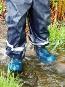 Child's wellies splashing in a puddle