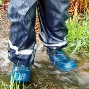 Child's wellies splashing in a puddle